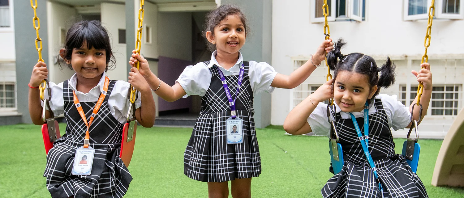 Pre-primary children playing on the campus swings