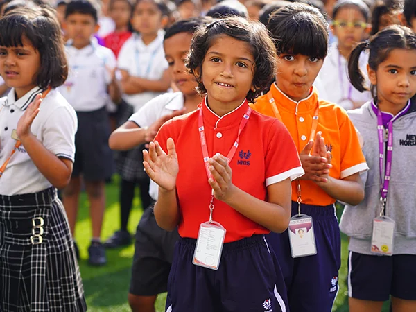 NHIS students applauding together on the school field