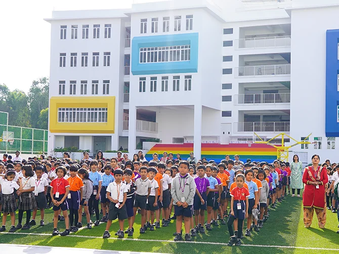 NHIS students standing together at the morning assembly in front of the campus building