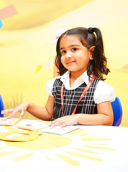 A pre-primary learner at work in a bright classroom