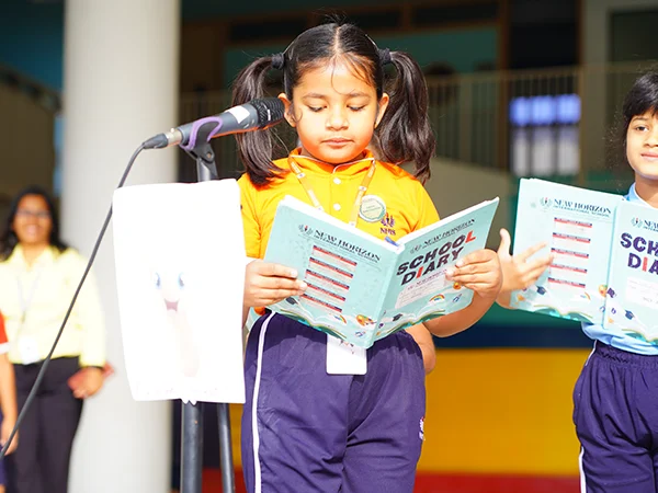 A young NHIS student reading aloud at the morning assembly