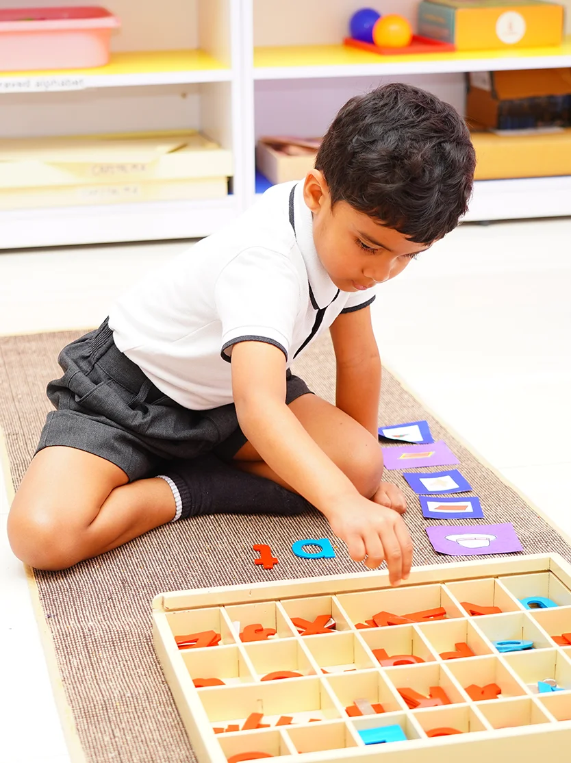 Early years student working with movable alphabet materials