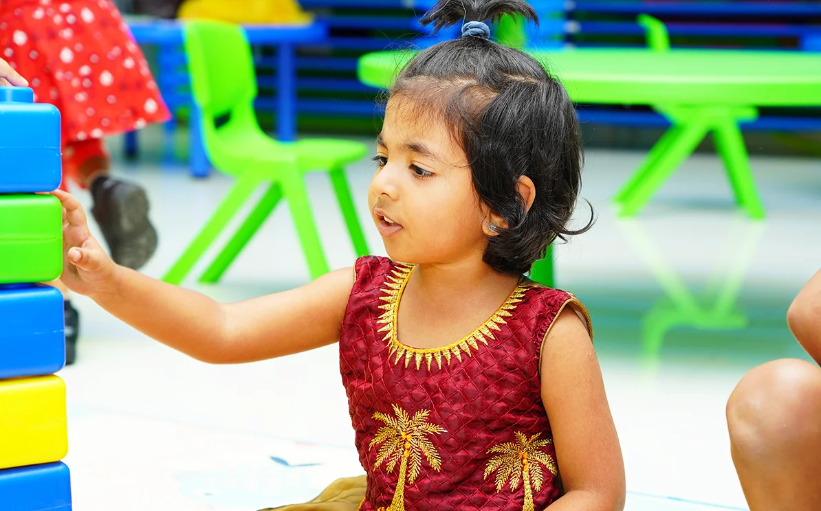 Pre-primary child building with colourful blocks