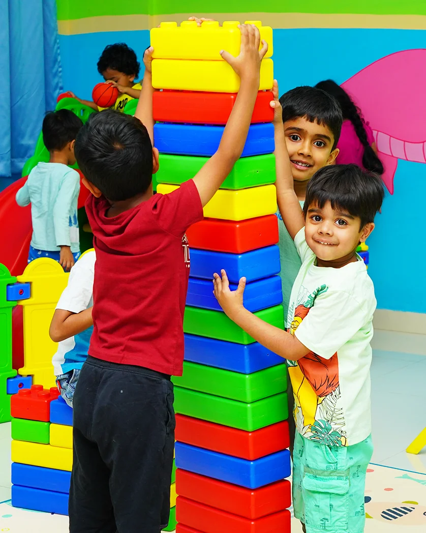Pre-primary children stacking giant building blocks