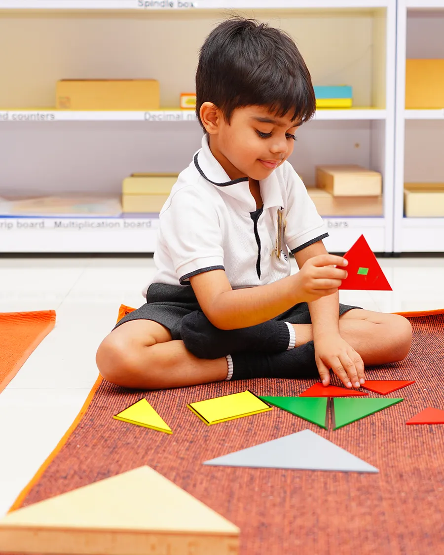 A young learner working with Montessori shape materials
