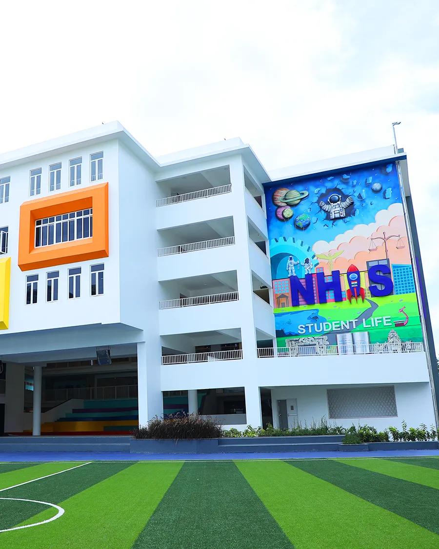 NHIS campus facade with the student life mural and sports turf