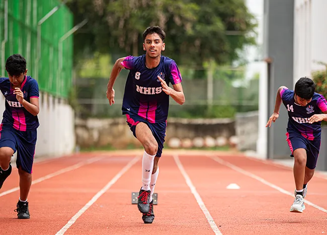 NHIS athletes sprinting on the campus track