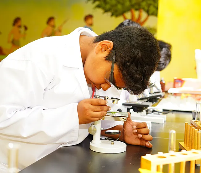 A student examining a slide under a microscope