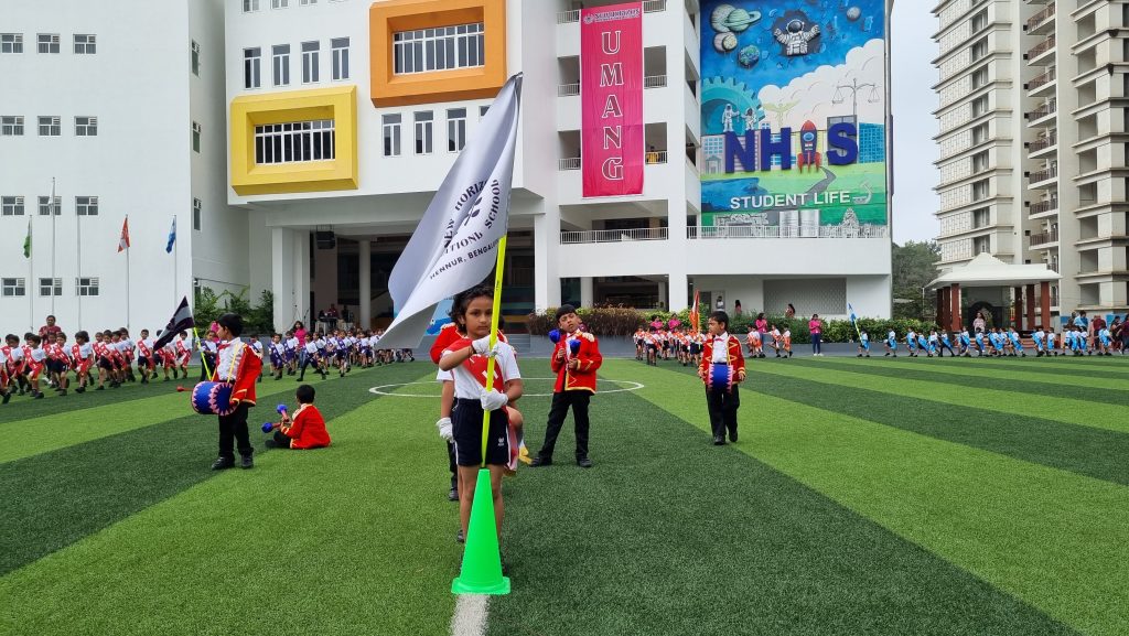 Pre-Primary students of NHIS Bengaluru holding the flag of honour