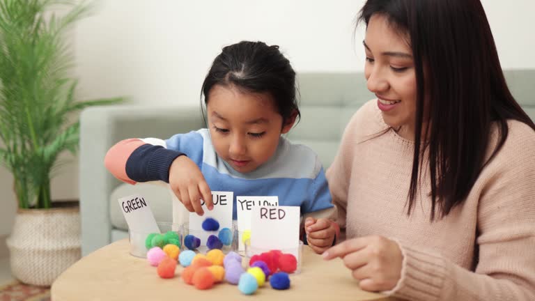 Asian kid playing didactic game with his mom at home - Montessori education concept. High quality 4k footage